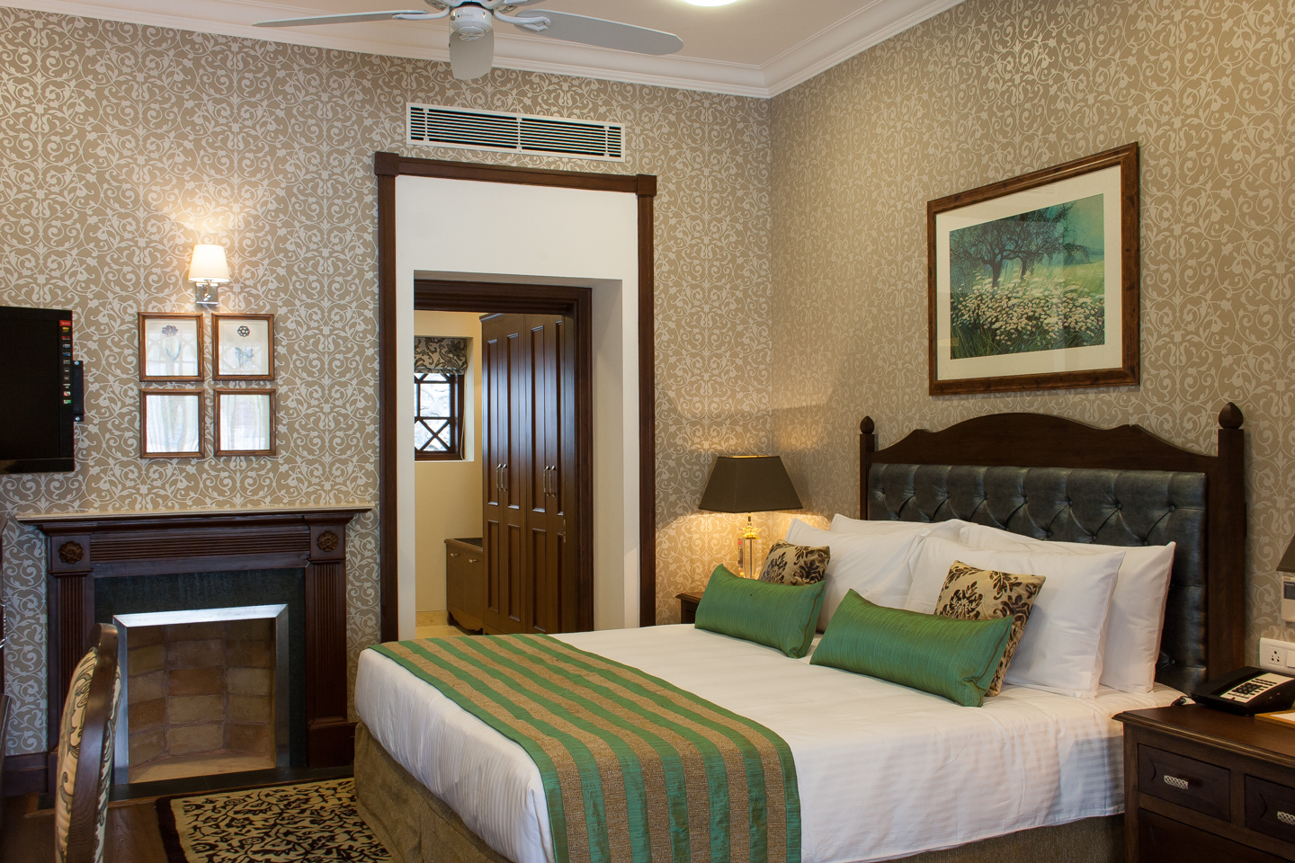 The bed has a leather headboard. The dressing room is beyond.