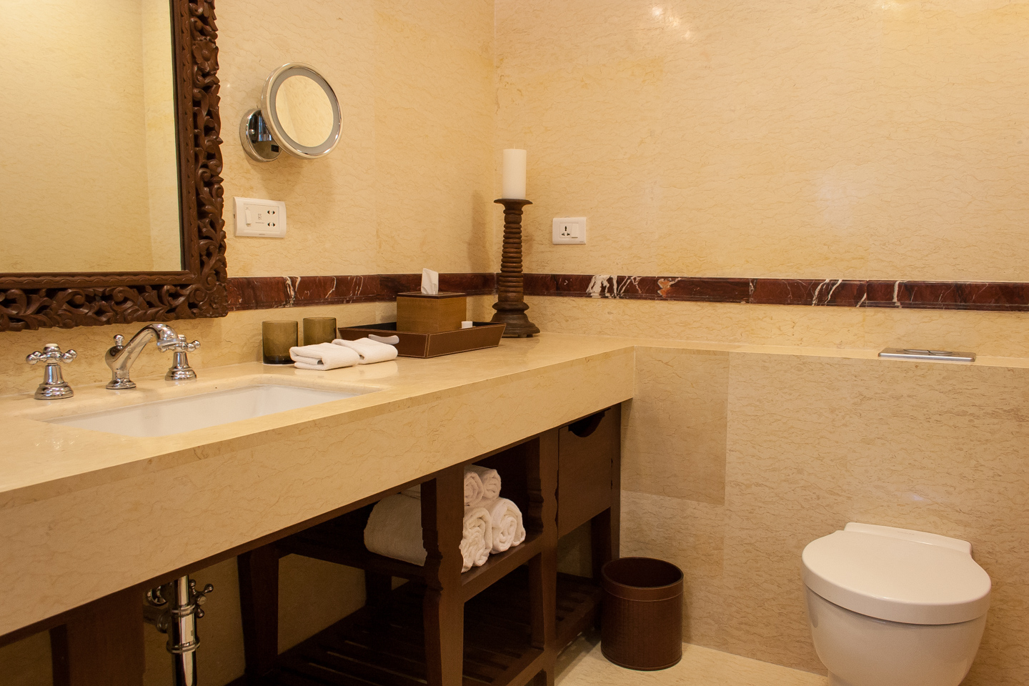 The marble walls are highlighted with trim of carved red marble. The stone counter has a wooden stand below.