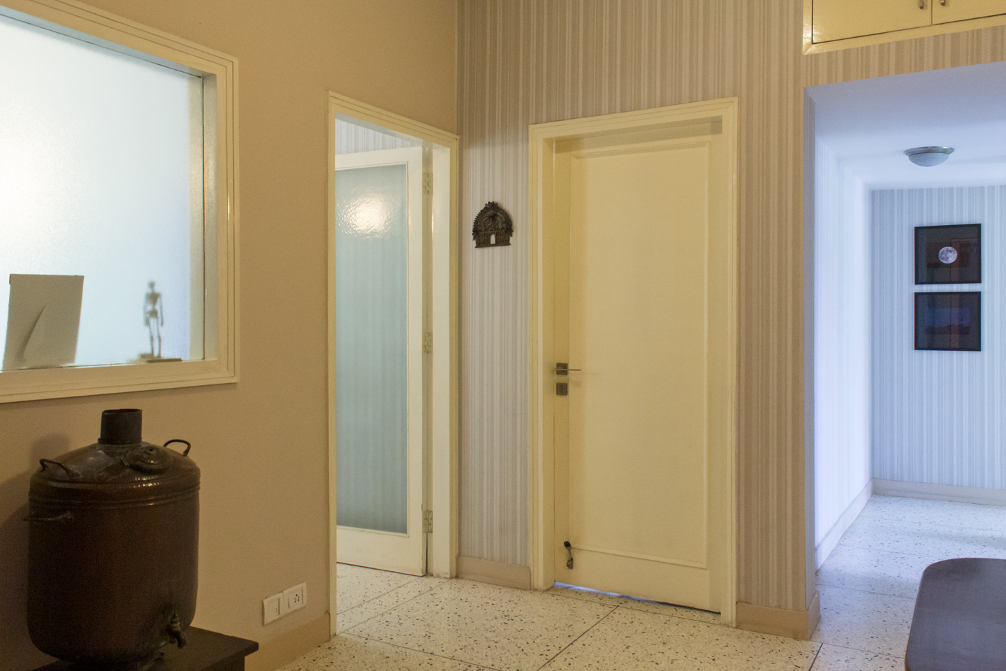 The lobby with door to the dining room on the left. The corridor to the right leads to two bedrooms. The door in the middle used to lead to the drawing room.