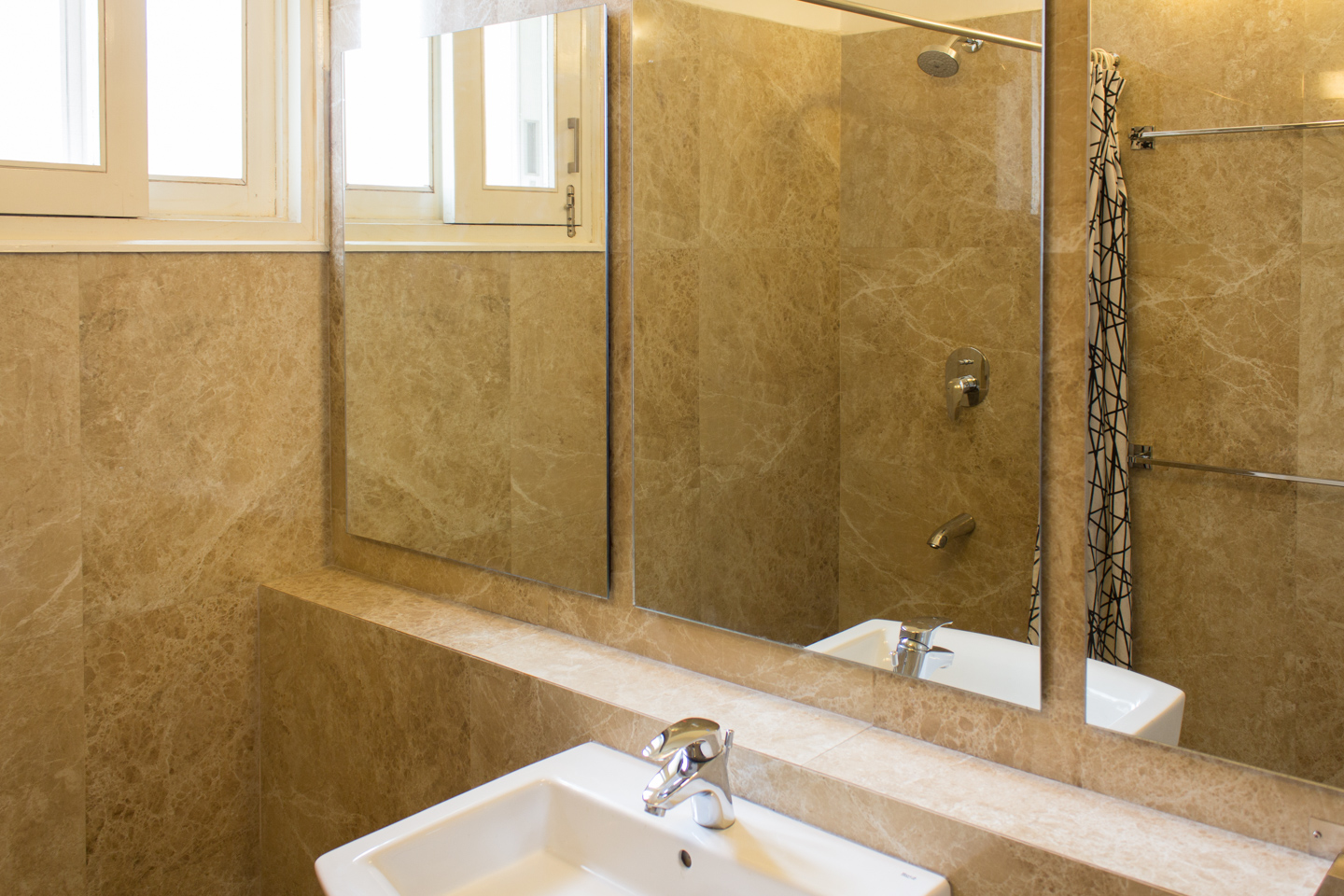 The master bathroom is minimal in design. The long, narrow ledge obviates the need for a counter. This makes the bathroom feel much bigger.